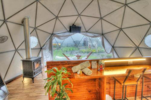 a room with a table and a stove in a yurt at Mantra Glamping & Chalets in Zacatlán