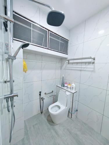 a white bathroom with a toilet and a shower at Zzora Home 28 in Alor Setar
