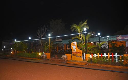 a sign in front of a building at night at Hills and Valleys Resort in Dapoli