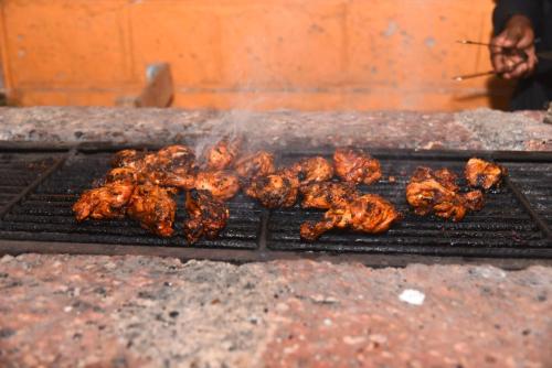 a bunch of food cooking on a grill at Hills and Valleys Resort in Dapoli