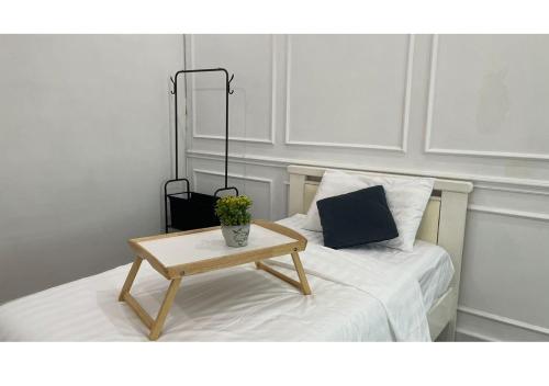 a bed with a coffee table with a pillow and a bag at Permai Homestay King in Bukit Mertajam