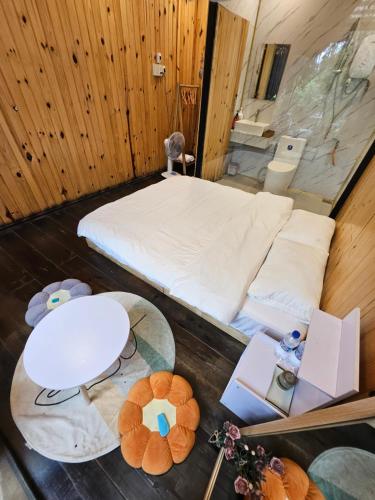 a small room with a bed and a table at Nhà Bắp in Da Lat