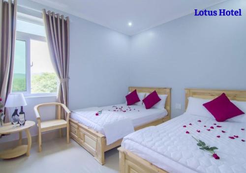 a bedroom with two beds and a window at Lotus Phú Quốc Hotel in Phu Quoc