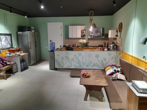 een keuken met groene muren en een tafel in een kamer bij YO Guesthouse in Tasjkent