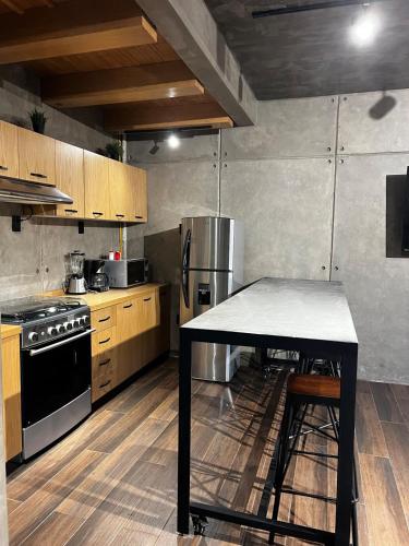 a kitchen with a table and a stainless steel refrigerator at Casa las palmerasmeras in Chalco de Díaz Covarrubias