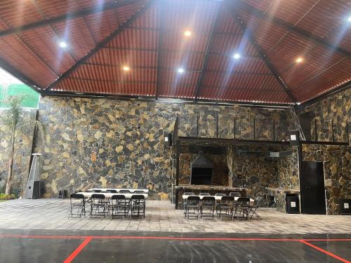 a group of tables and chairs in a stone building at Casa las palmerasmeras in Chalco de Díaz Covarrubias