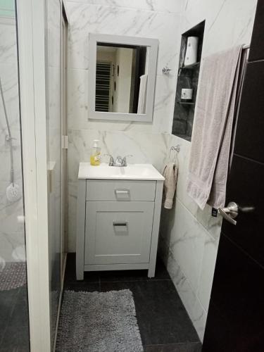 a white bathroom with a sink and a mirror at central and tourist residence in Ciudad Madero