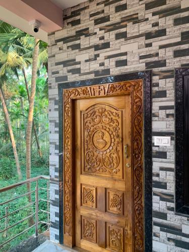 a wooden door in a stone wall at Bethel Homestay Honnavar in Honāvar