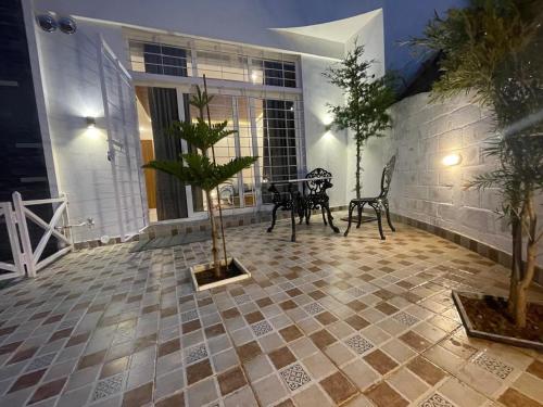 a patio with a table and chairs in a house at Orchard Valley View in Ooty