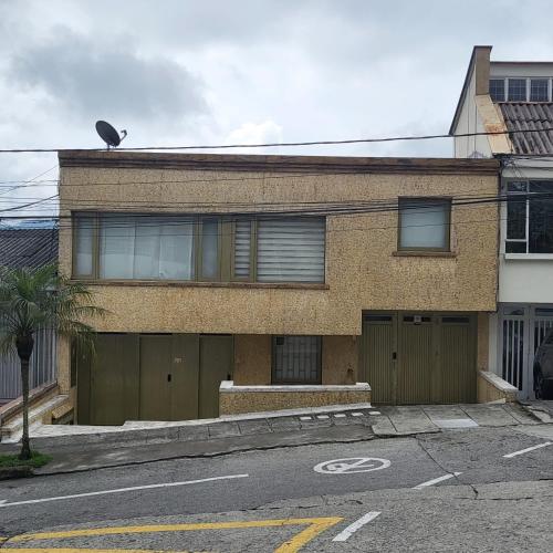 a brick house with a garage on a street at LA CASA DEL CABLE - Hermoso Apartamento - in Manizales