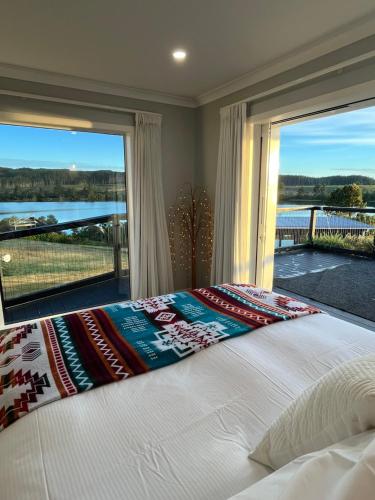 a bedroom with a bed and a large window at Luxury Lake House Retreat in Mangakino