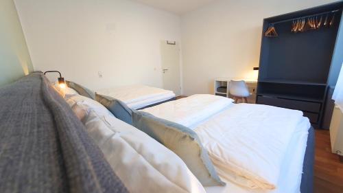 a bedroom with two beds and a blue headboard at Good Stay Aparthotel mit kostenlosen Parkplätzen in Dresden