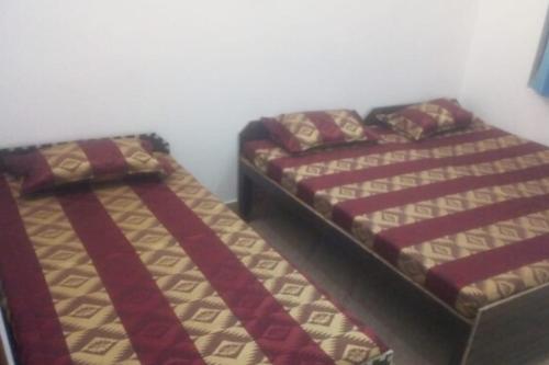 two beds sitting next to each other in a room at HOTEL PUSPWAN AND RESTAURANT by StayApart in Ukhimath