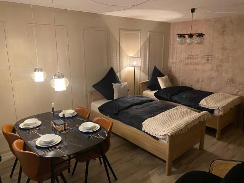 a bedroom with two beds and a table with plates on it at Stylisches City Apartment mit Balkon und Garage in Leipzig