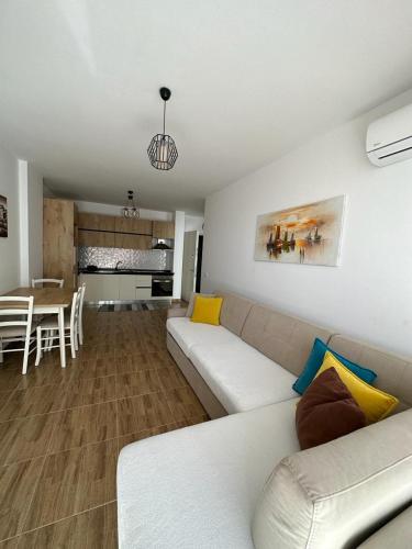 a living room with a white couch and a table at Sea View Mario's Apartment in Lezhë