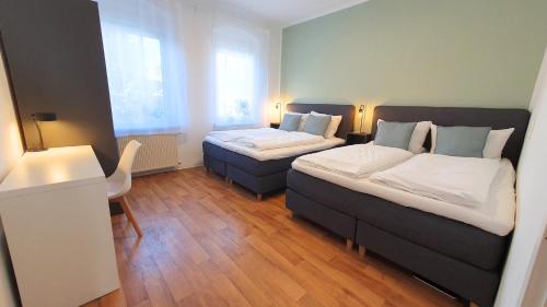 a room with two beds and a chair in it at Good Stay Aparthotel mit kostenlosen Parkplätzen in Dresden