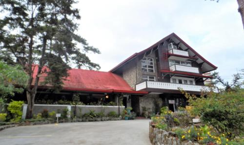 a large building with a red roof at Log Cabin Hotel - Baguio in Baguio