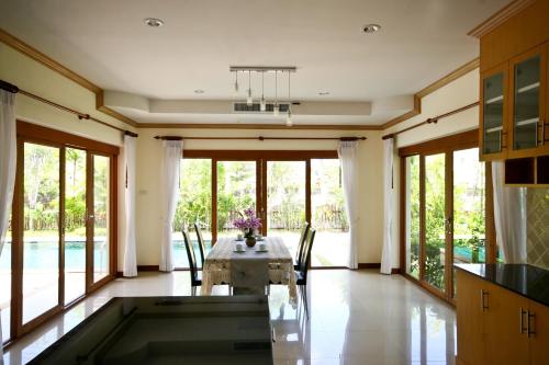 a kitchen and dining room with a table and chairs at Bangtao Tropical Residence Resort and Spa in Surin Beach