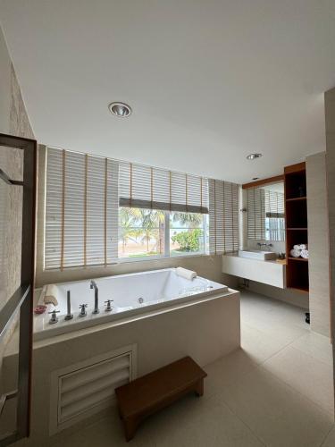 a large bathroom with a large tub and a window at Tusita Wellness Resort in Paktako
