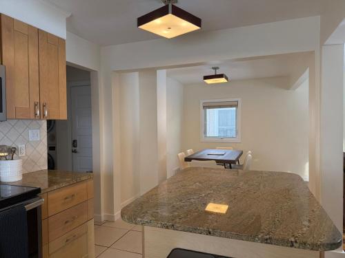 a kitchen with a counter top and a table at 2Bed Bright & Stylish Ritchie Urban Retreat in Edmonton
