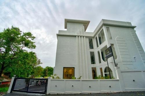 a white building with a fence in front of it at Goa Courtyard by the porto Arpora in Baga