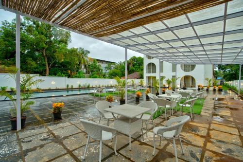 a group of tables and chairs on a patio at Goa Courtyard by the porto Arpora in Baga