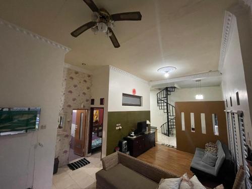 a living room with a couch and a ceiling fan at Tropica Villa, Kuningan in Jalaksana