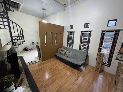 a living room with a couch and wooden floors at Tropica Villa, Kuningan in Jalaksana