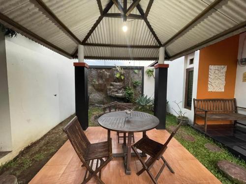 a patio with a table and chairs on a porch at Tropica Villa, Kuningan in Jalaksana