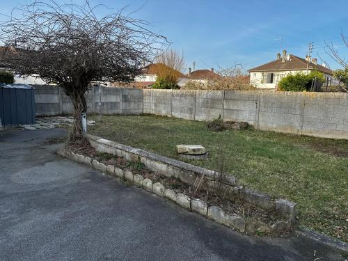 un arbre dans une cour à côté d'une clôture dans l'établissement Charmante maison de ville, à Margny-lès-Compiègne