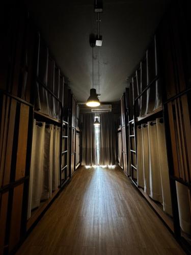 an empty room with bookshelves and a hallway with a light at Yaksa Private in Bangkok