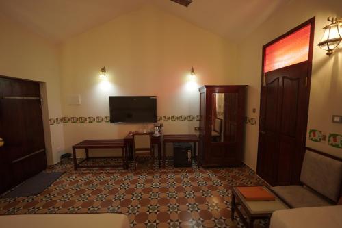 a living room with a couch and a television at Deshadan Chola , Thanjavur in Thanjāvūr