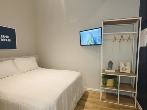 a bedroom with a bed and a tv on a wall at Apê Santos Praia do Gonzaga in Santos