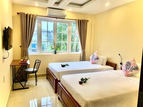 a hotel room with two beds and a window at Aman Riverside Hotel in Hoi An