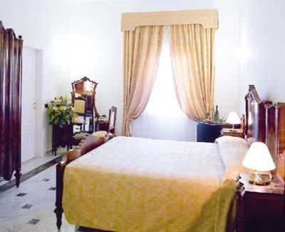 a bedroom with a yellow bed and a window at Alla Rocca Hotel Conference & Restaurant in Bazzano