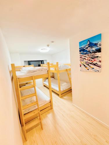 a room with two bunk beds and a painting on the wall at L!fe Apartment Hakuba in Hakuba