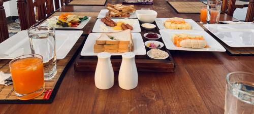 een tafel met borden met eten en drinken bij The Heritage Inn in Kandy