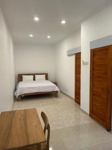 une chambre avec un lit et une table en bois dans l'établissement Astika Asri Homestay, à Dalung