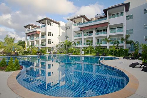 a swimming pool in front of a building at Bangtao Tropical Residence Resort and Spa in Surin Beach