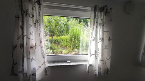 a window with curtains in a room with a view at Schönes Appartement am Weser-Radweg in Minden