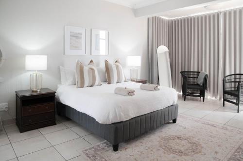 a bedroom with a bed with two towels on it at Seabreeze at the Beach in Strand