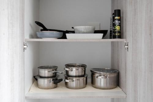 a shelf with pots and pans in a kitchen at Seabreeze at the Beach in Strand