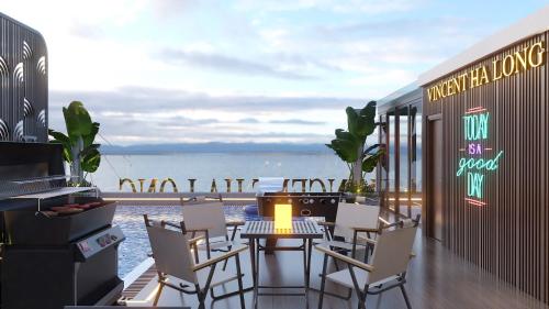 a patio with a table and chairs and the ocean at Vincent Halong Hotel in Ha Long
