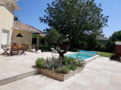 une statue d'une femme debout à côté d'une piscine dans l'établissement Chez Guillaume et Béquie, à Biganos