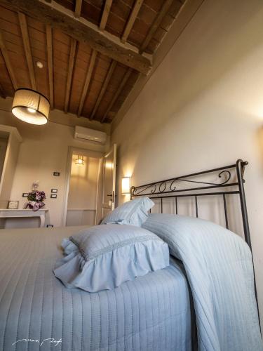 a bedroom with a bed with blue sheets and a ceiling at punti di vista in Bibbona