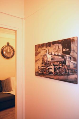 une peinture d'un train sur un mur à côté d'une horloge dans l'établissement Cozy stash between Paris & Disney, à Neuilly-Plaisance