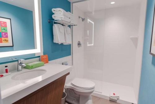 a bathroom with a sink and a toilet and a shower at Howard Johnson by Wyndham Anaheim Hotel & Water Playground in Anaheim