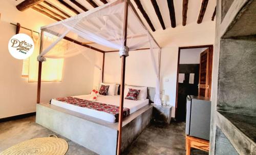 a bedroom with a canopy bed in a room at Diana Place in Paje