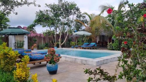 a swimming pool in a backyard with a patio furniture at Diana Place in Paje