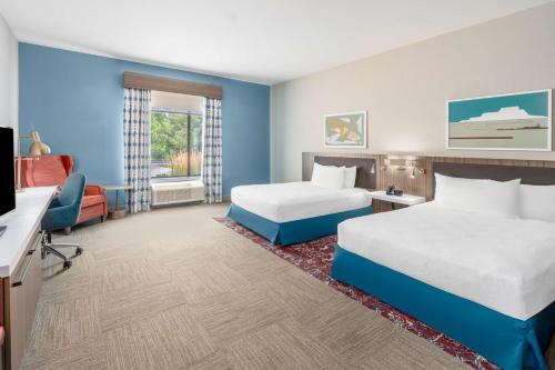 a hotel room with two beds and a flat screen tv at Hilton Garden Inn Trinidad Downtown in Trinidad